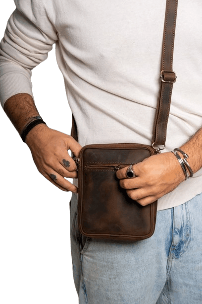 a lady putting a laptop into a brown leather laptop bag